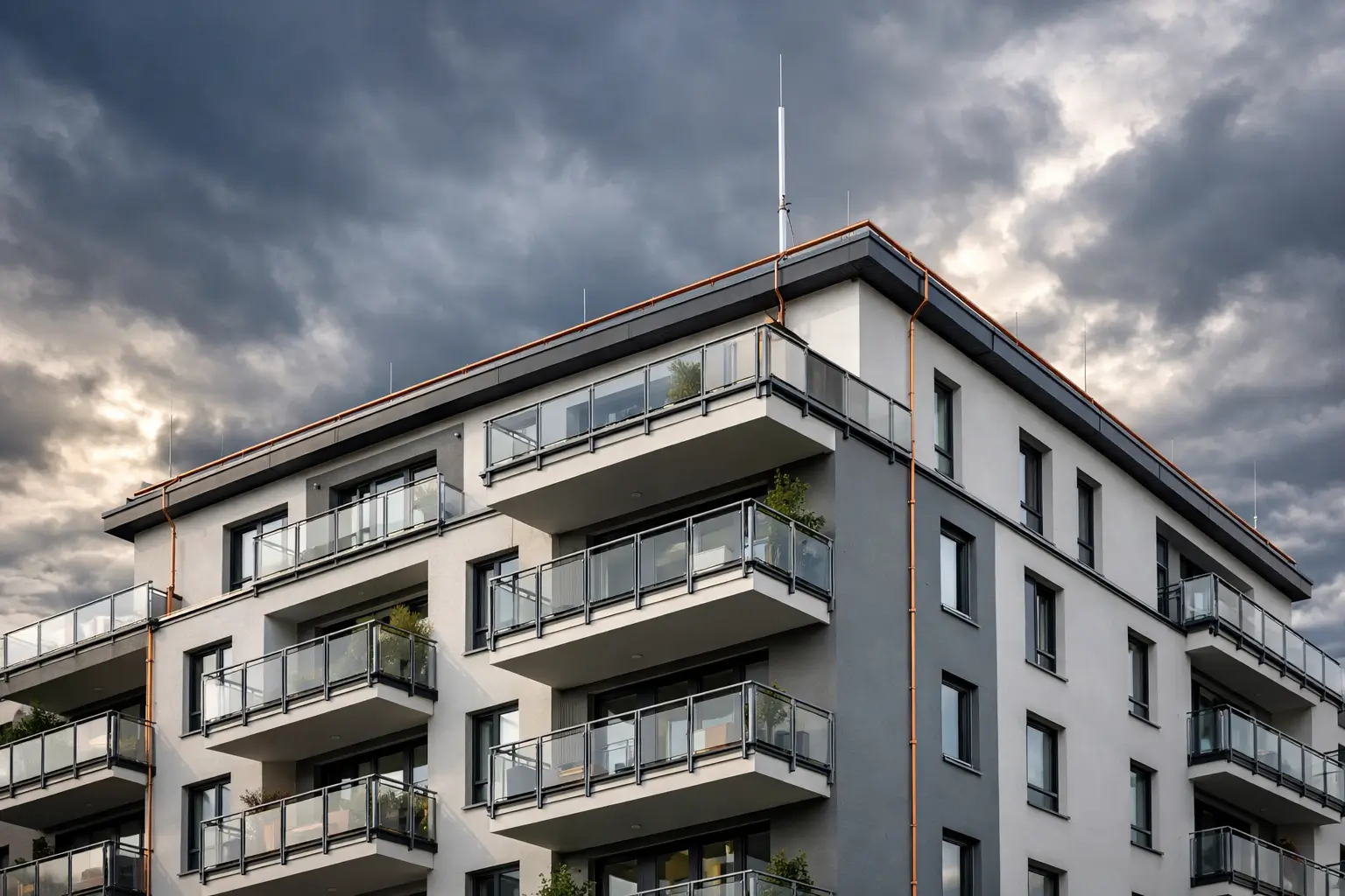 Blitzschutz Haus – Mehrfamilienhaus mit sichtbarem Blitzableiter und Fangstange auf dem Dach